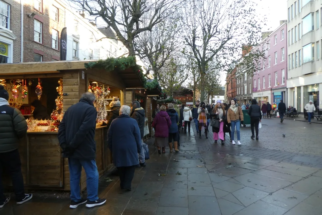 Wooden chalet stalls at a town-centre Christmas market. Photographed in York, not in Sevenoaks.