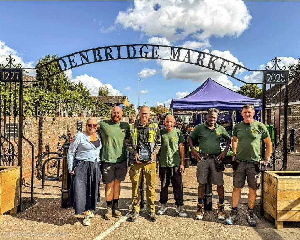 Edenbridge Town Council's market team with the award under the Edenbridge Market arch at Market Yard